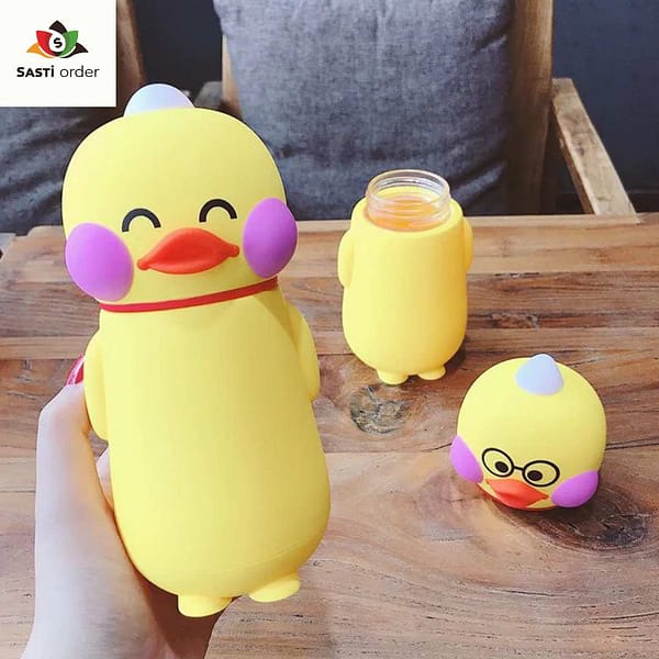 "Funny yellow duck bottle with a playful design, placed on a picnic table with colorful beverages."